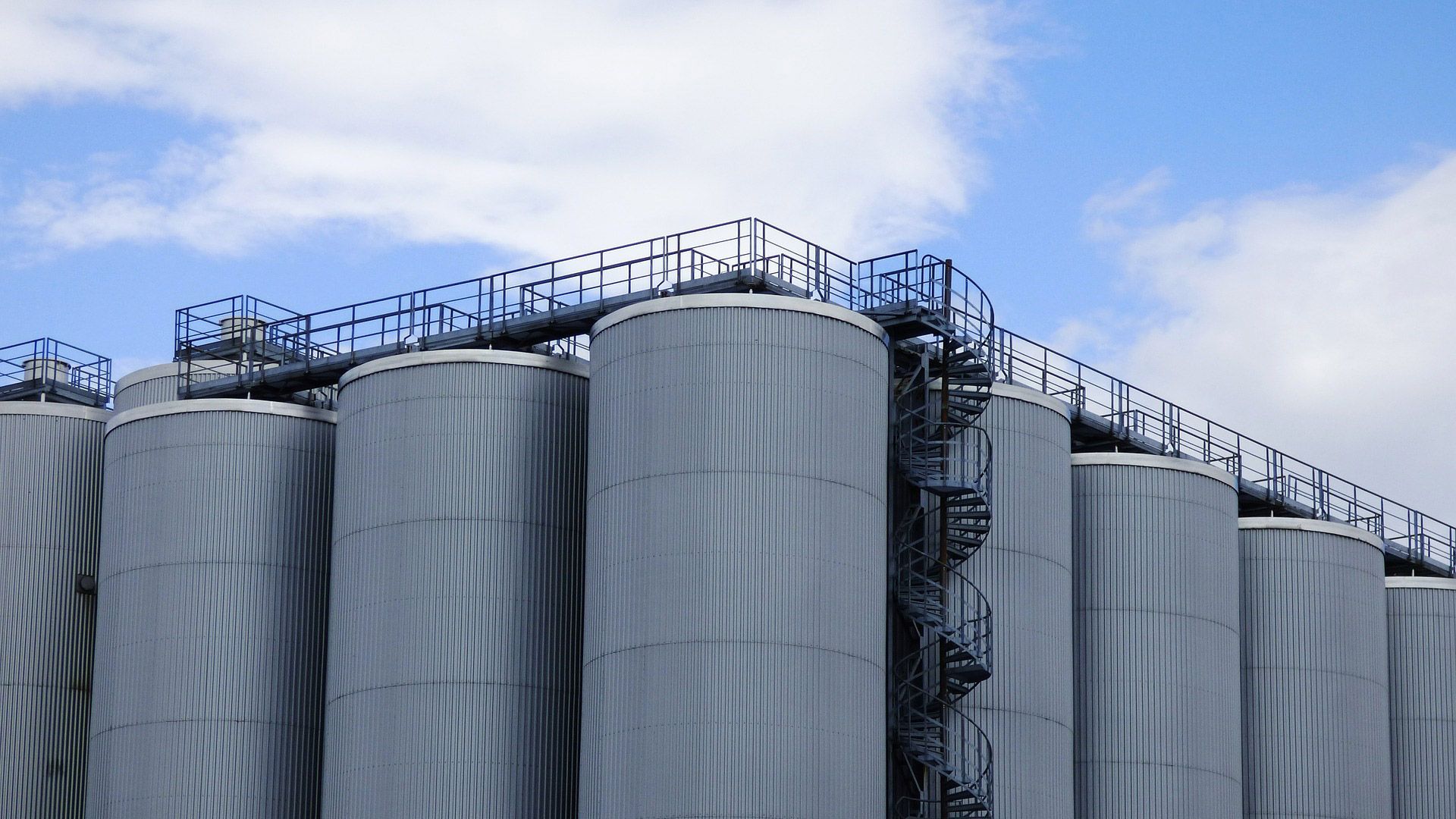 Industrial storage silos beneath a blue sky